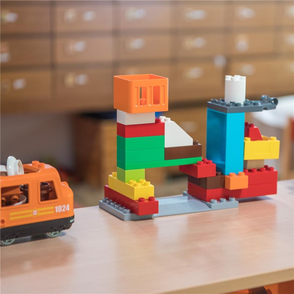 Ein Tisch, auf dem Legosteine und eine Spielzeugbahn angeordnet sind, ideal für kreatives Spielen.